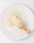 cream colored grains on wooden spoon on white plate