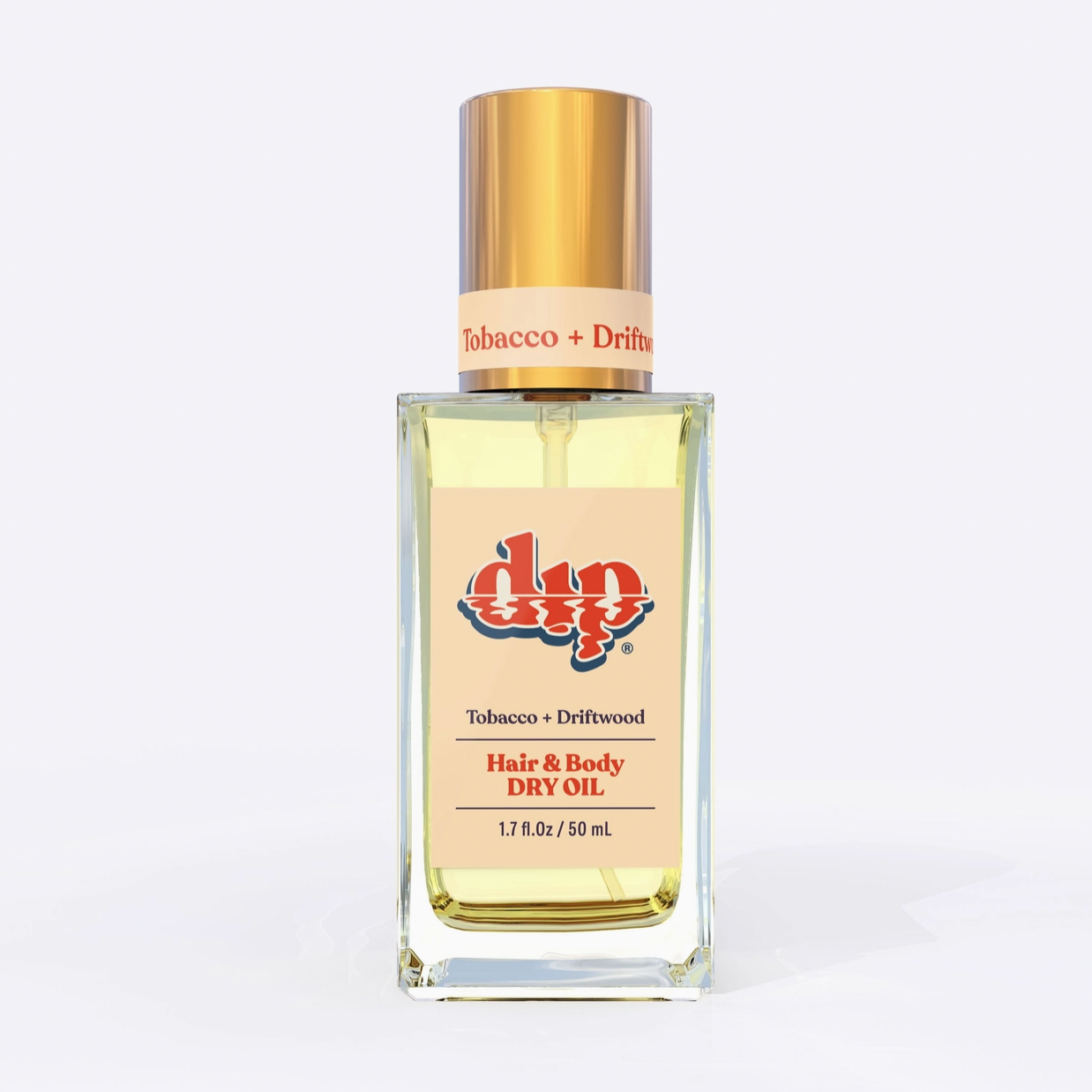 Square glass bottle with gold top and tan label tobacco and driftwood hair and body dry oil on white background. 